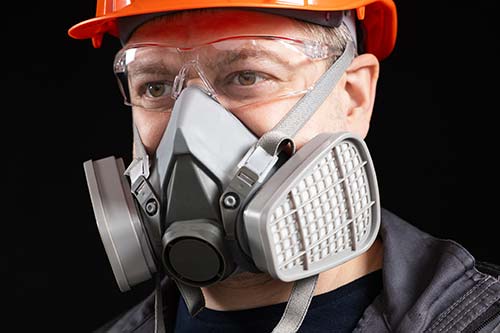 Technician in a mask smiles, breathing easy with GMG’s air quality standards