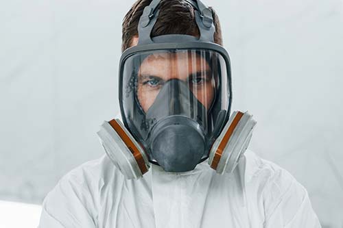 Technician in a mask smiles, breathing easy with GMG’s air quality standards