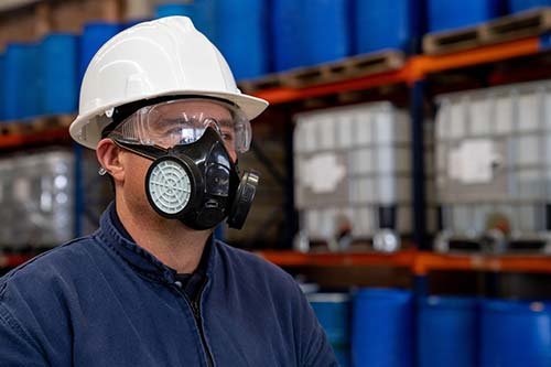 Technician in a mask smiles, breathing easy with GMG’s air quality standards