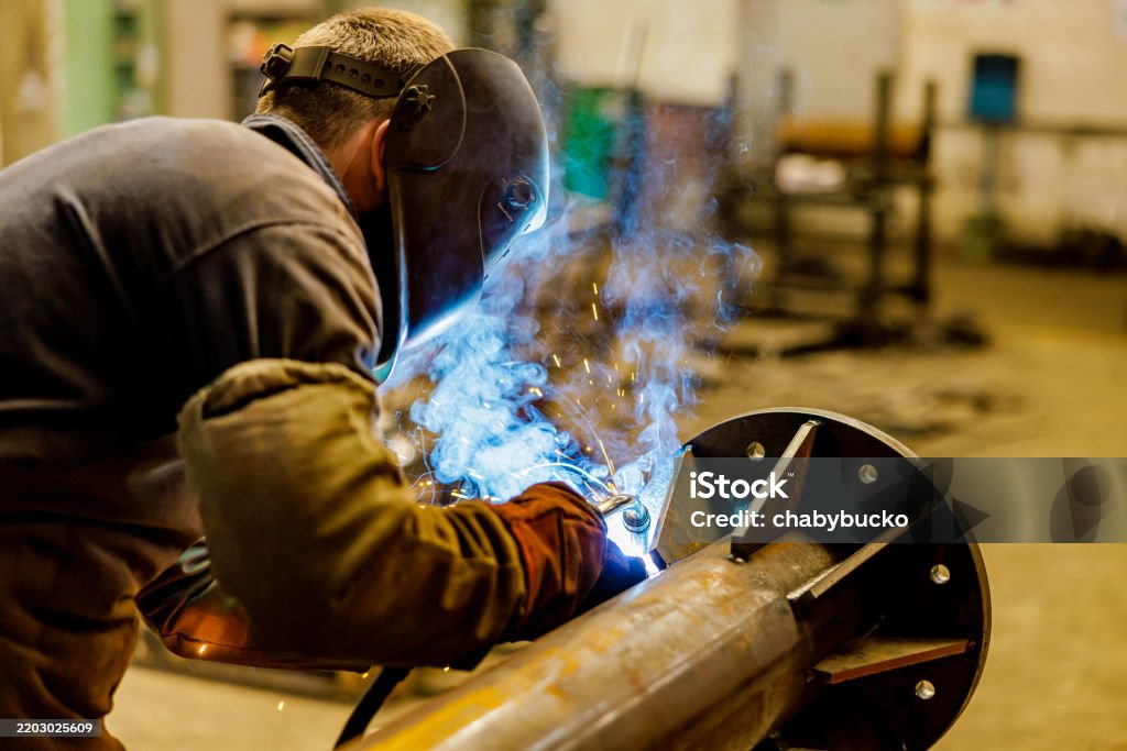 EHS-trained welder practicing fire prevention in a collision repair shop