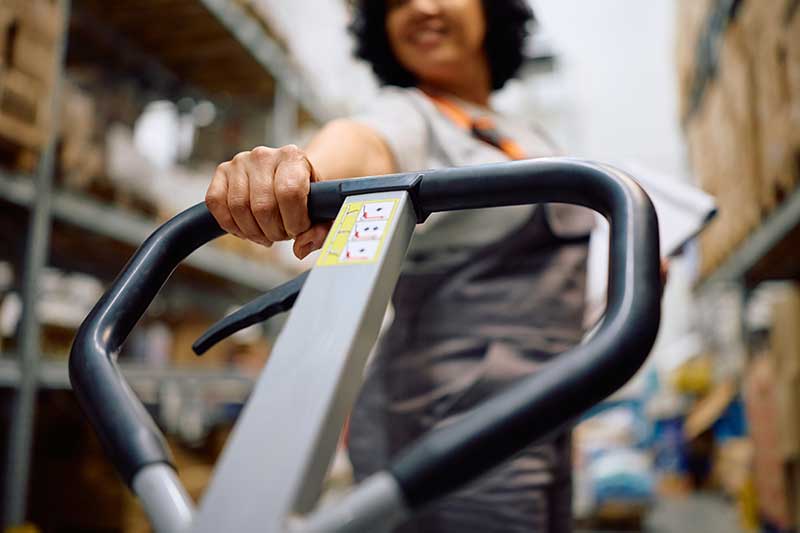 Workers holding helmets discuss GMG EnviroSafe safety compliance training in a warehouse setting