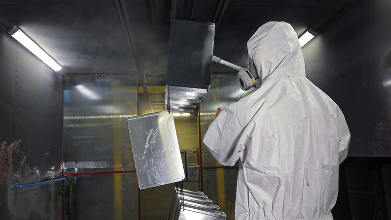 Technician in a mask smiles, breathing easy with GMG’s air quality standards