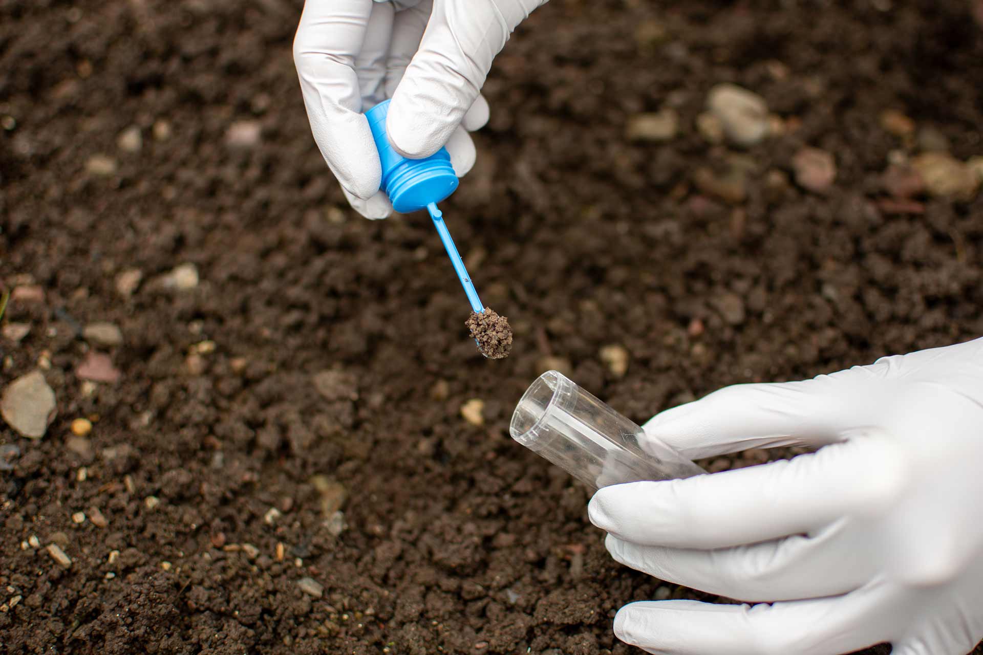 Workers holding helmets discuss GMG EnviroSafe safety compliance training in a warehouse setting
