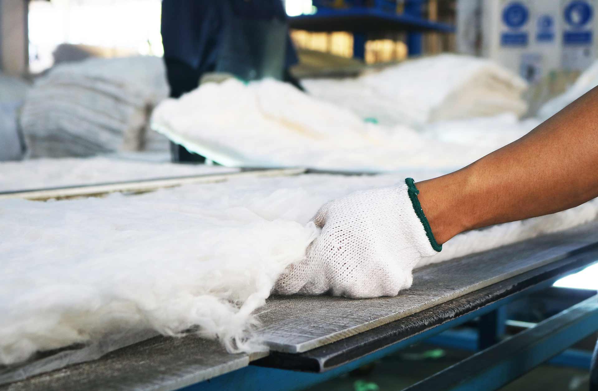 Workers holding helmets discuss GMG EnviroSafe safety compliance training in a warehouse setting