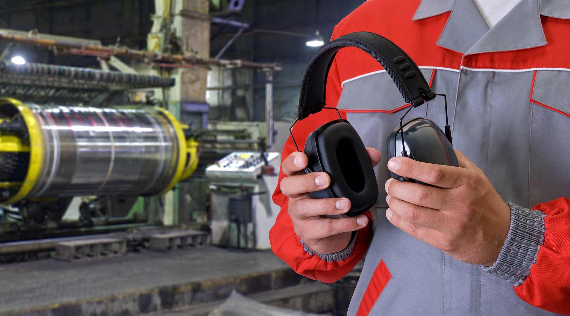 Workers holding helmets discuss GMG EnviroSafe safety compliance training in a warehouse setting