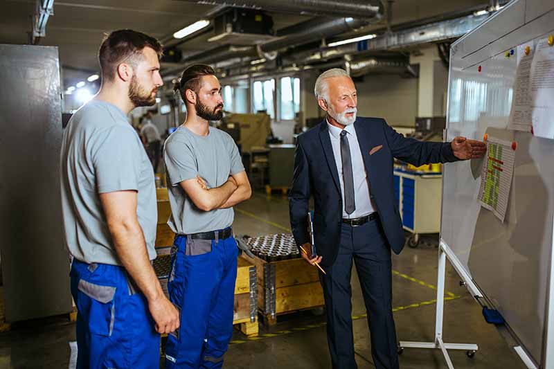 Mechanic checks car undercarriage in GMG-compliant noise-controlled workshop