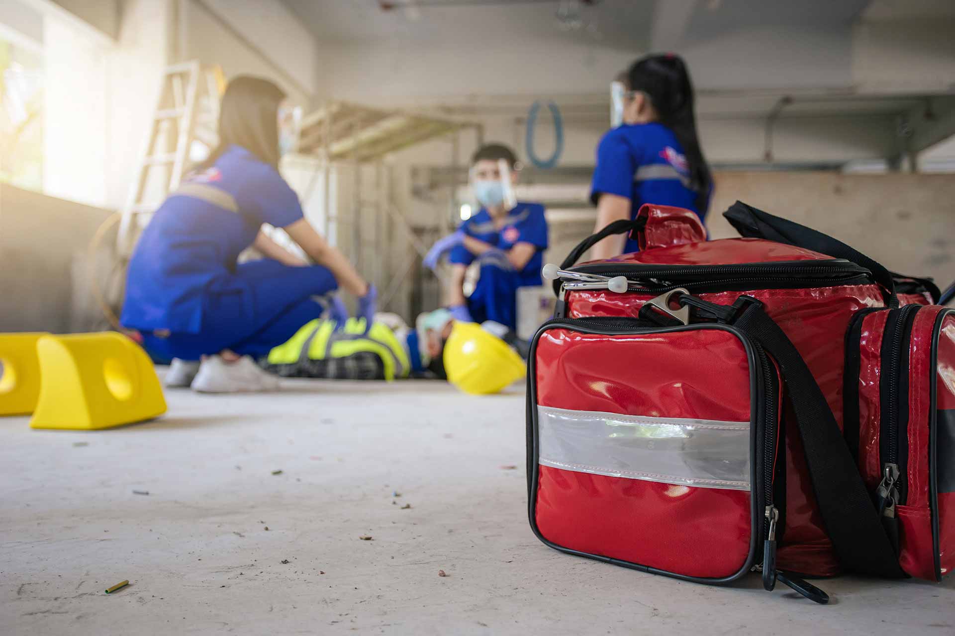 Workers holding helmets discuss GMG EnviroSafe safety compliance training in a warehouse setting