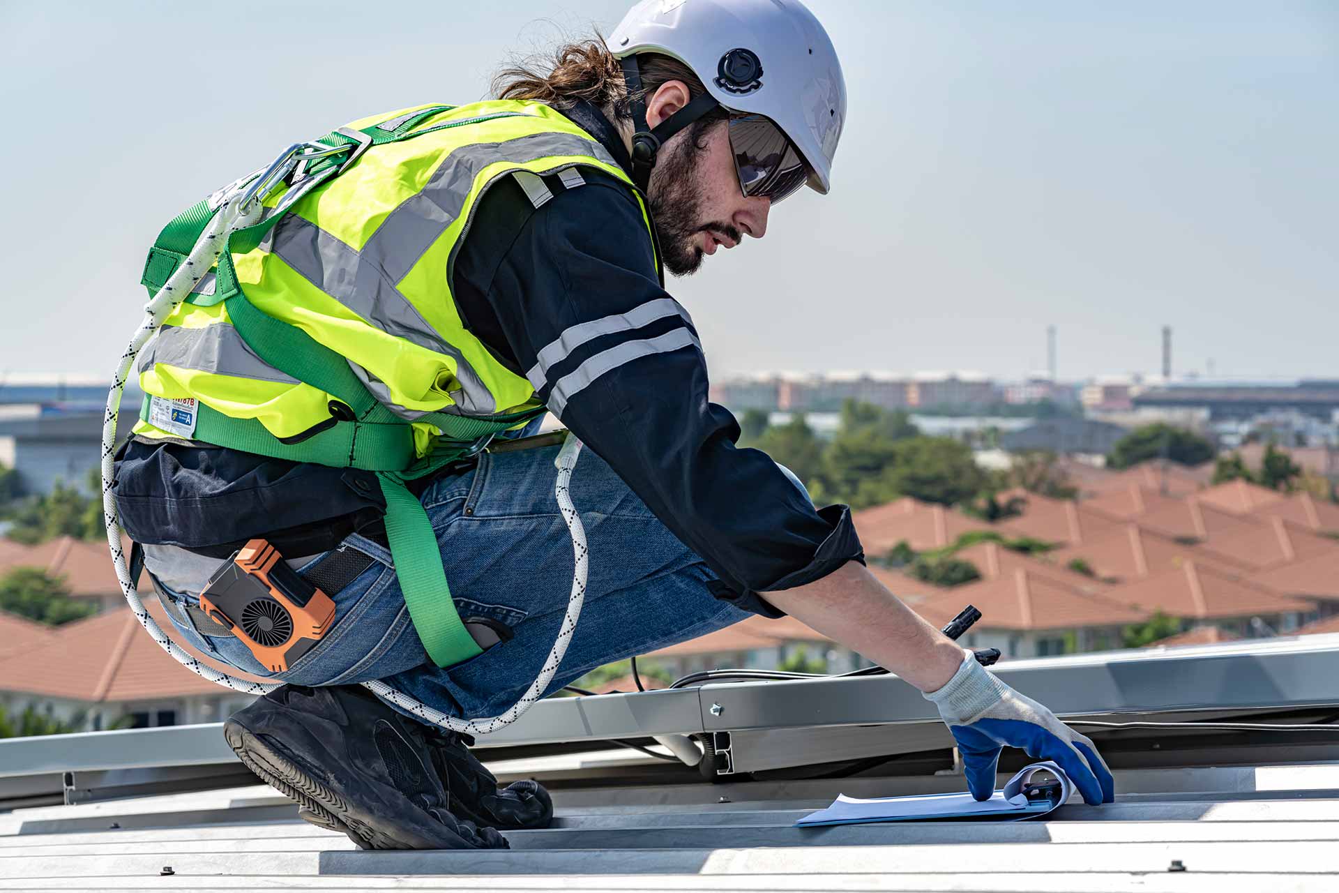 Workers holding helmets discuss GMG EnviroSafe safety compliance training in a warehouse setting