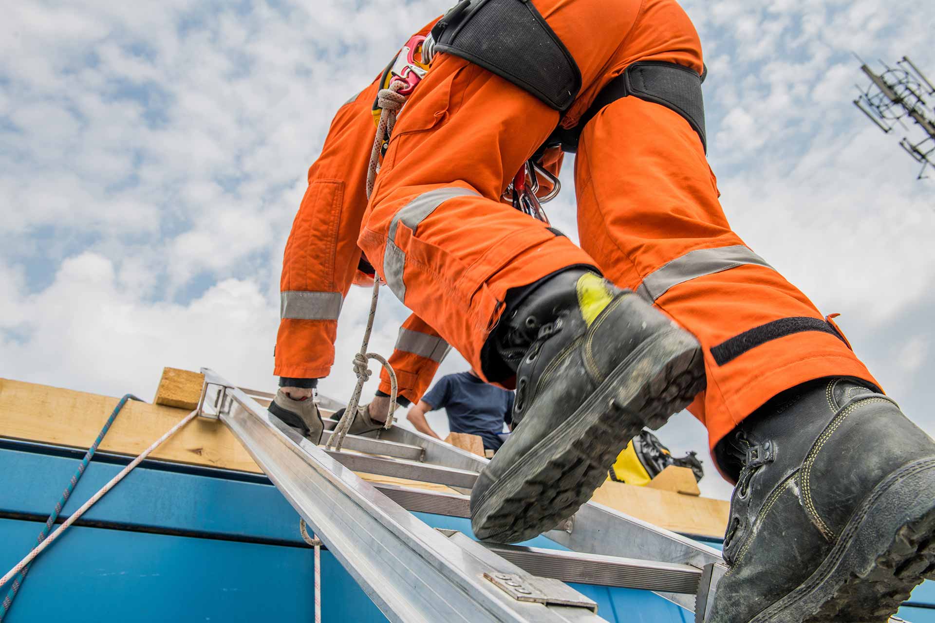 Workers holding helmets discuss GMG EnviroSafe safety compliance training in a warehouse setting