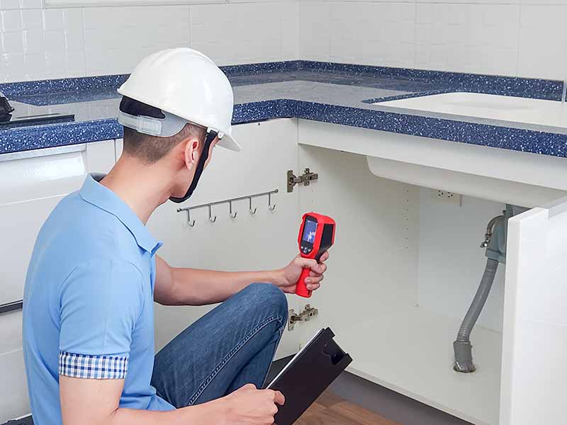 Mechanic checks car undercarriage in GMG-compliant noise-controlled workshop