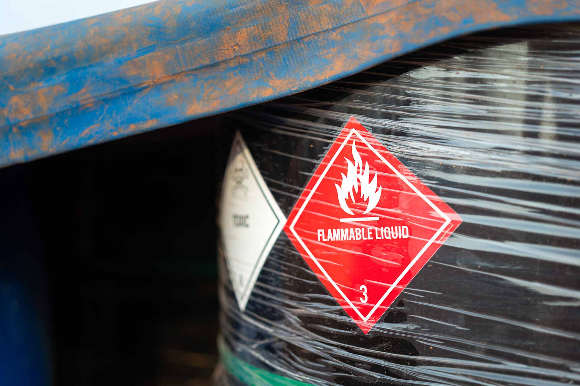 Workers holding helmets discuss GMG EnviroSafe safety compliance training in a warehouse setting