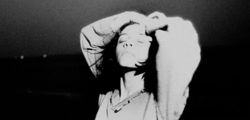 Grainy film and black and white filter edited with VSCO of person with hands raised over head