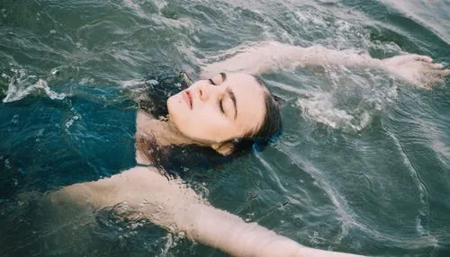 Woman floating on back in water before VSCO filter applied