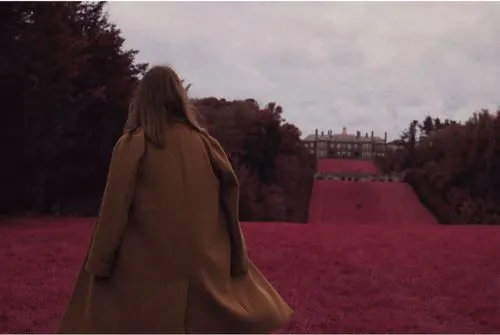 Woman in wool coat facing away on building lawn edited with Infrared IR1 filter on VSCO by Sasha Stepanyuk