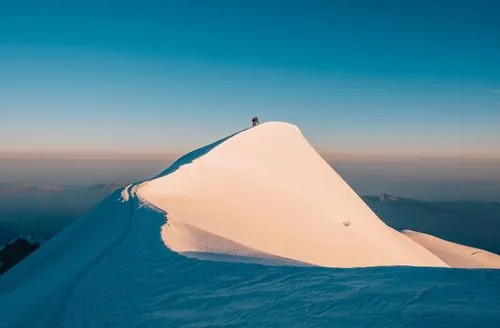 Two mountaineers standing in the distance on snowy Mont Blanc peak at sunrise by Simone Enei professional photographer