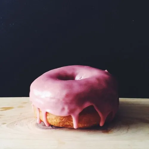 Professional food photography of a donut with pink frosting by Mark Weinberg
