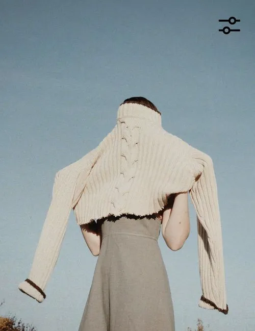 VSCO photo editor icon overlaid on a picture of a woman pulling a cream knit sweater over her head