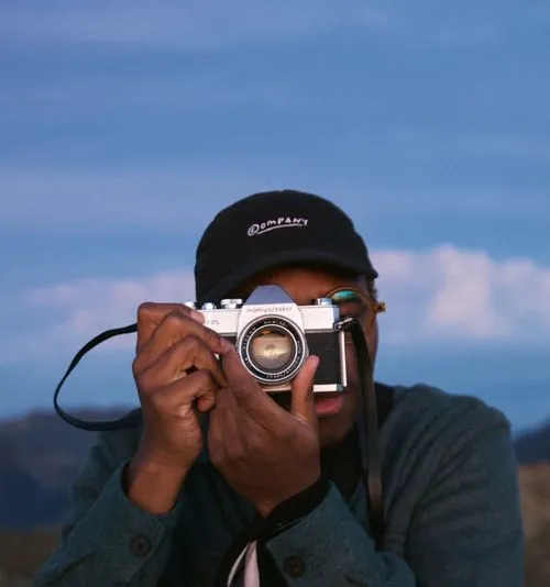 Freelance photographer from VSCO behind a camera lens in outdoor landscape
