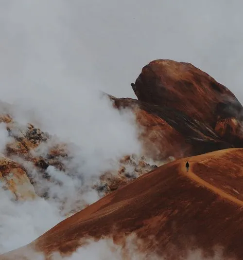 VSCO repost of hiker on red hills with low clouds