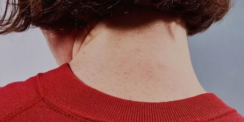 Back of woman's freckled neck wearing a red crew neck sweater by fashion photographer Cody Guilfoyle