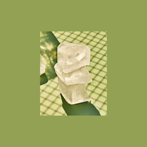 Green photo border added to image of stacked ice cubes on a green tennis court under the shadow of the net