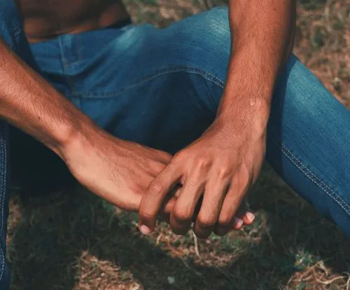 Person sitting with arms on knees wearing blue jeans edited with the VSCO WE5 photo filter