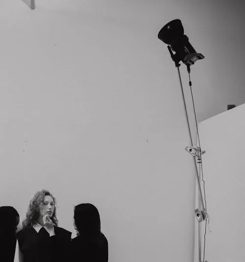 Makeup artist touching up model during commercial photography photoshoot