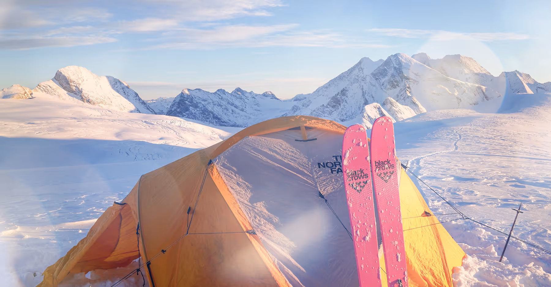 Lens flare effect added to photo of tent on snowy mountain