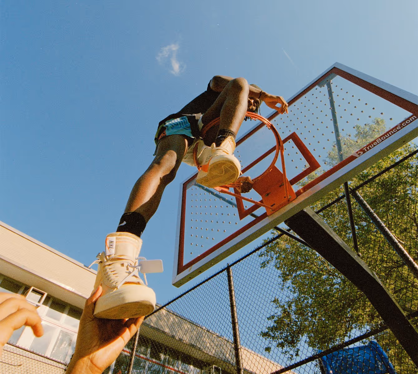 Video still of basketball player on top of hoop before cropping