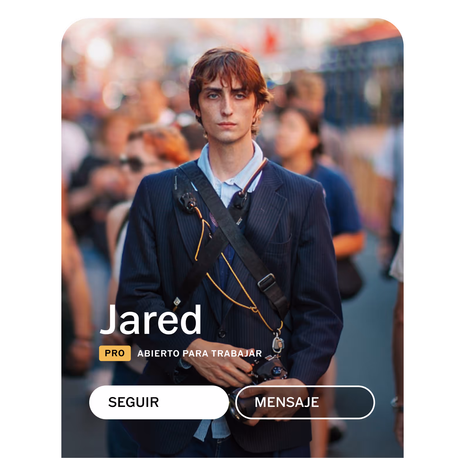 Perfil de la comunidad de VSCO para el fotógrafo Jared con un blazer azul marino que sostiene una cámara con una correa en el pecho, de pie en una calle concurrida con etiquetas de interfaz de usuario de perfil PRO, Disponible para trabajar, Seguir y Mensaje