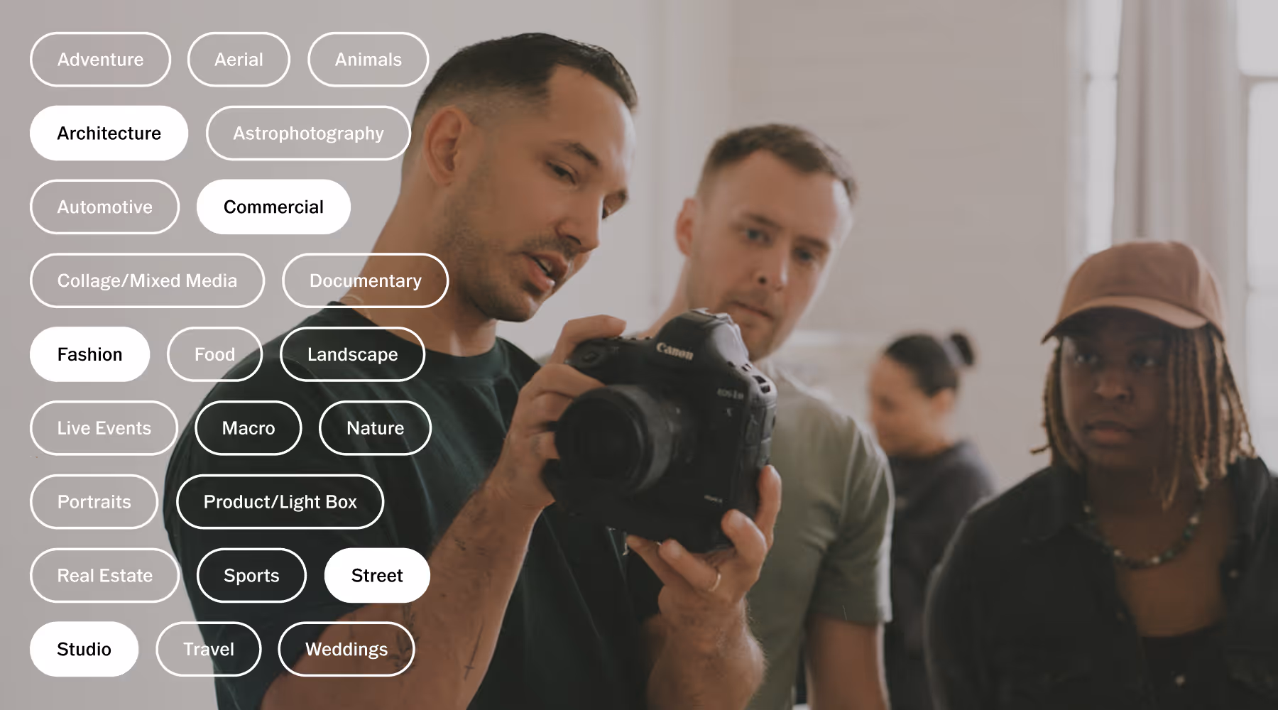2 photographers looking at a Canon camera screen held by a photography coach, with overlay buttons of types of photography niches