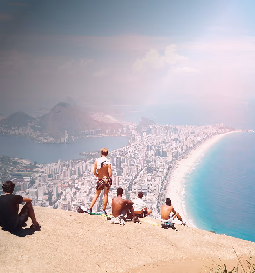 Film filter on a picture of a group of five people sitting and standing on a rocky cliff overlooking a sprawling city with tall buildings and a long beach by the ocean.