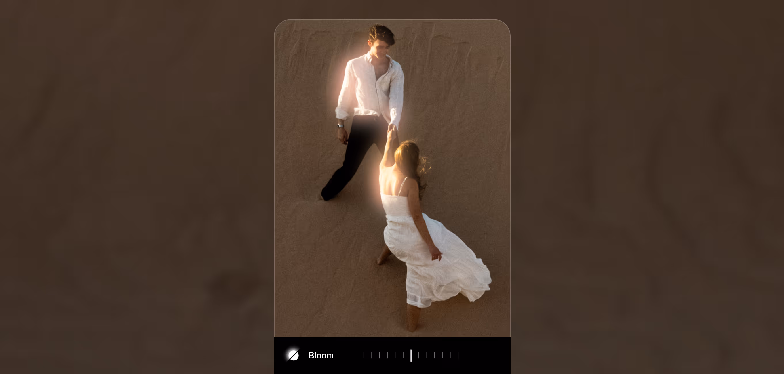 A man in a white shirt and black pants holding hands with a woman in a flowing white dress on a sandy surface, both glowing softly from dreamy Bloom effect with Capture camera UI overlaid.