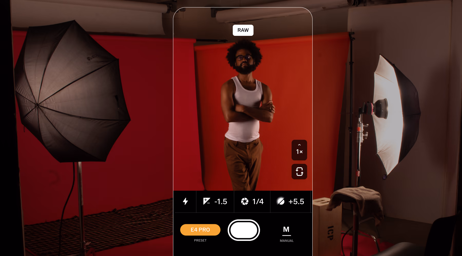 Smartphone screen showing a raw camera app capturing a man standing in a studio with red backdrop and lighting.