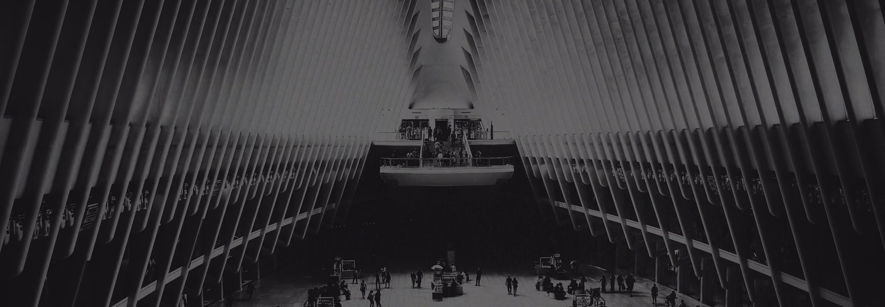 Large modern interior with high ribbed ceiling and people walking on ground and upper level.