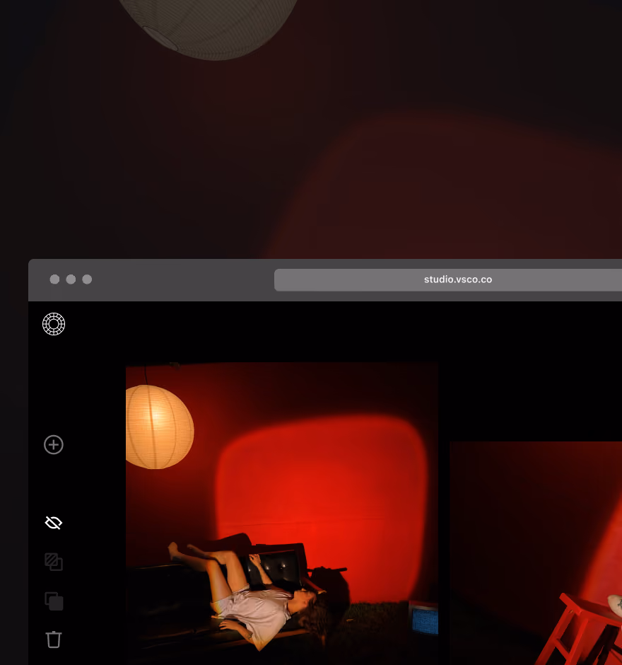 Online photo editor showing image of person lying on black sofa under paper lantern light casting red shadows on the wall behind.