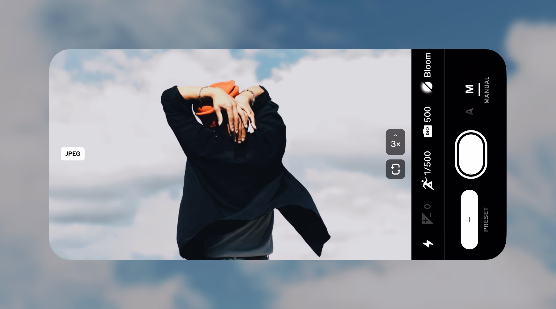 Person with orange beanie and black jacket seen from behind under a cloudy sky on a camera app screen.