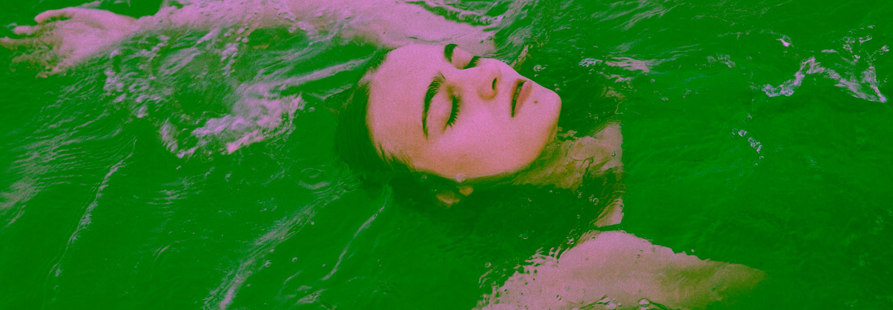 Young woman swimming backstroke face-up in water with eyes closed.