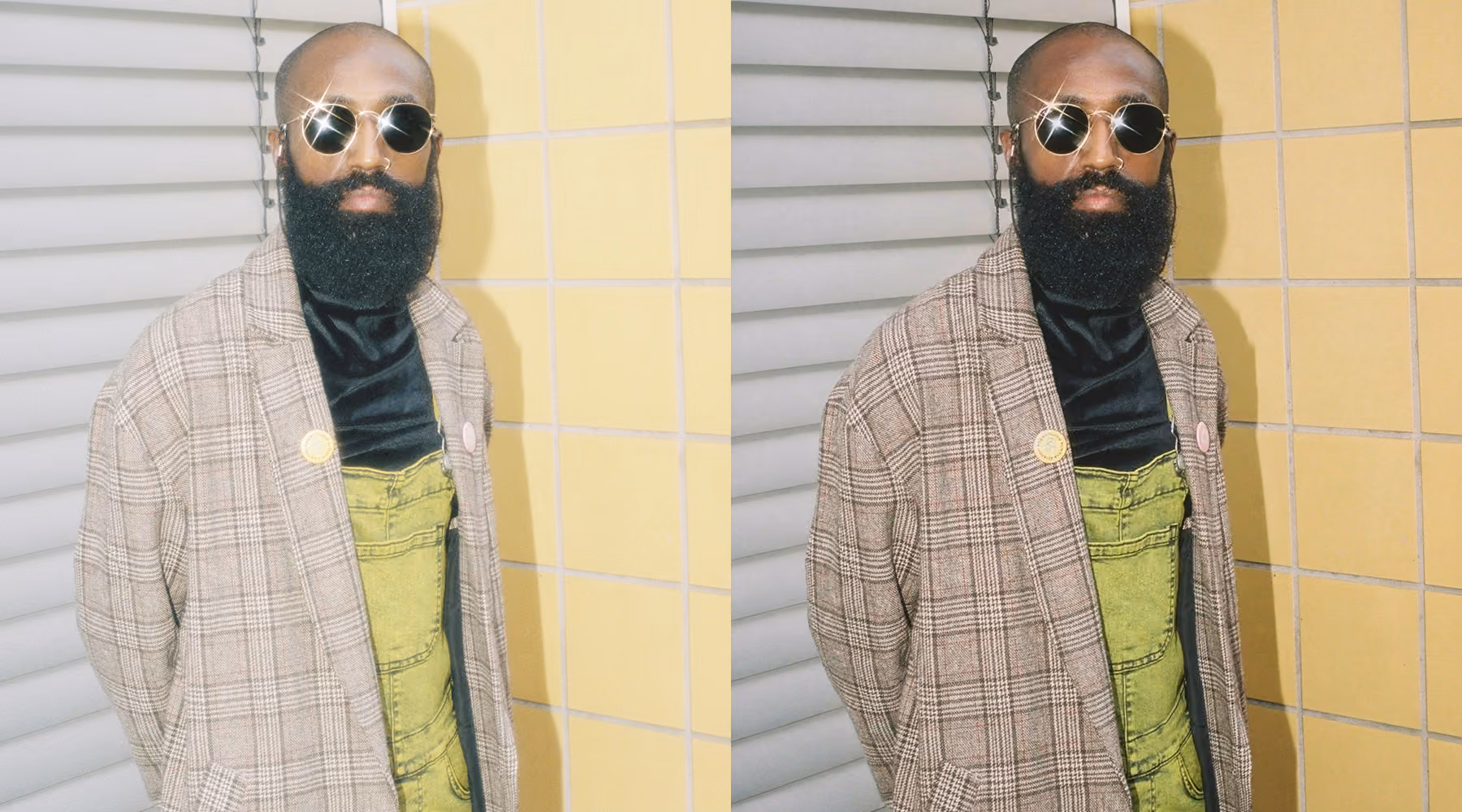 Man with a full beard and bald head wearing round sunglasses, a checked blazer over a black shirt, and a green garment, standing against a wall with yellow and white panels. Edited with AI Dehaze.