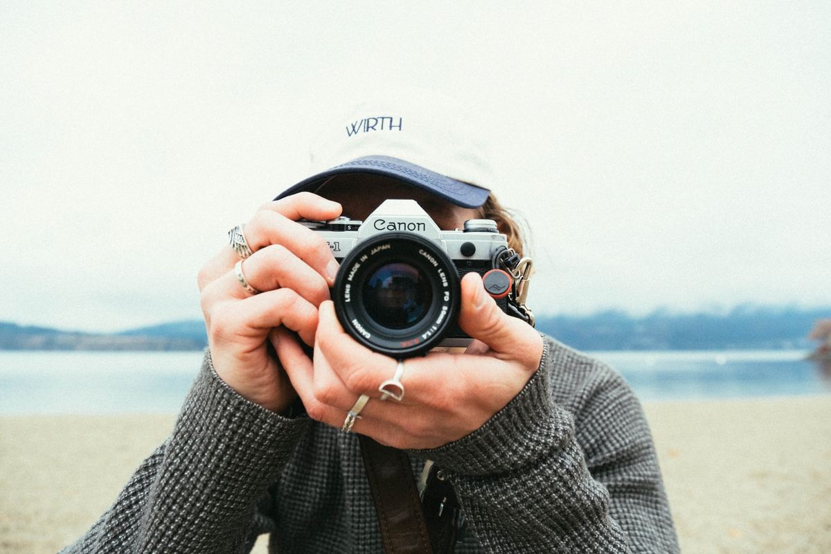 Photographer holding a film camera up to their face on a lakeshore, Kodak UltraMax 800 preset applied