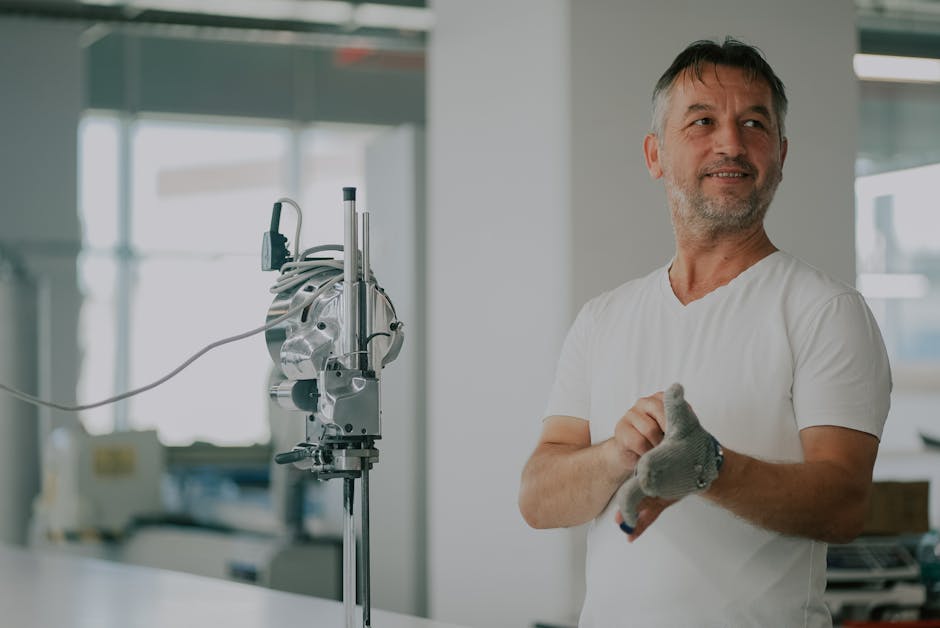 Adult man in an industrial workshop with textile machinery, preparing for work.