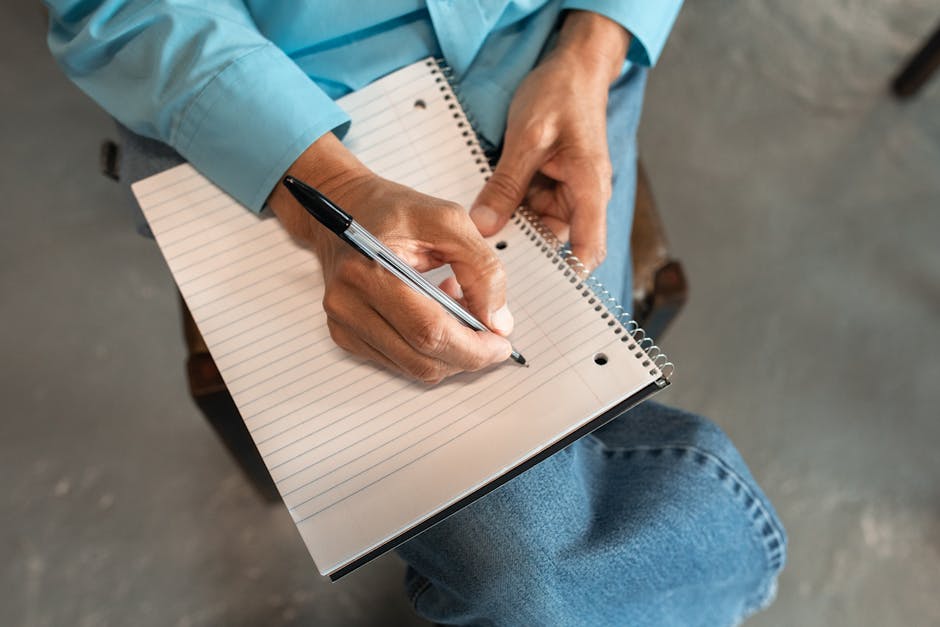 Close-up of a businessperson reviewing compliance documents in a notepad.