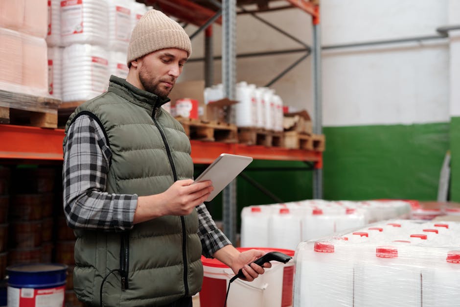 Man managing inventory with tablet in warehouse, focusing on efficiency in storage operations.