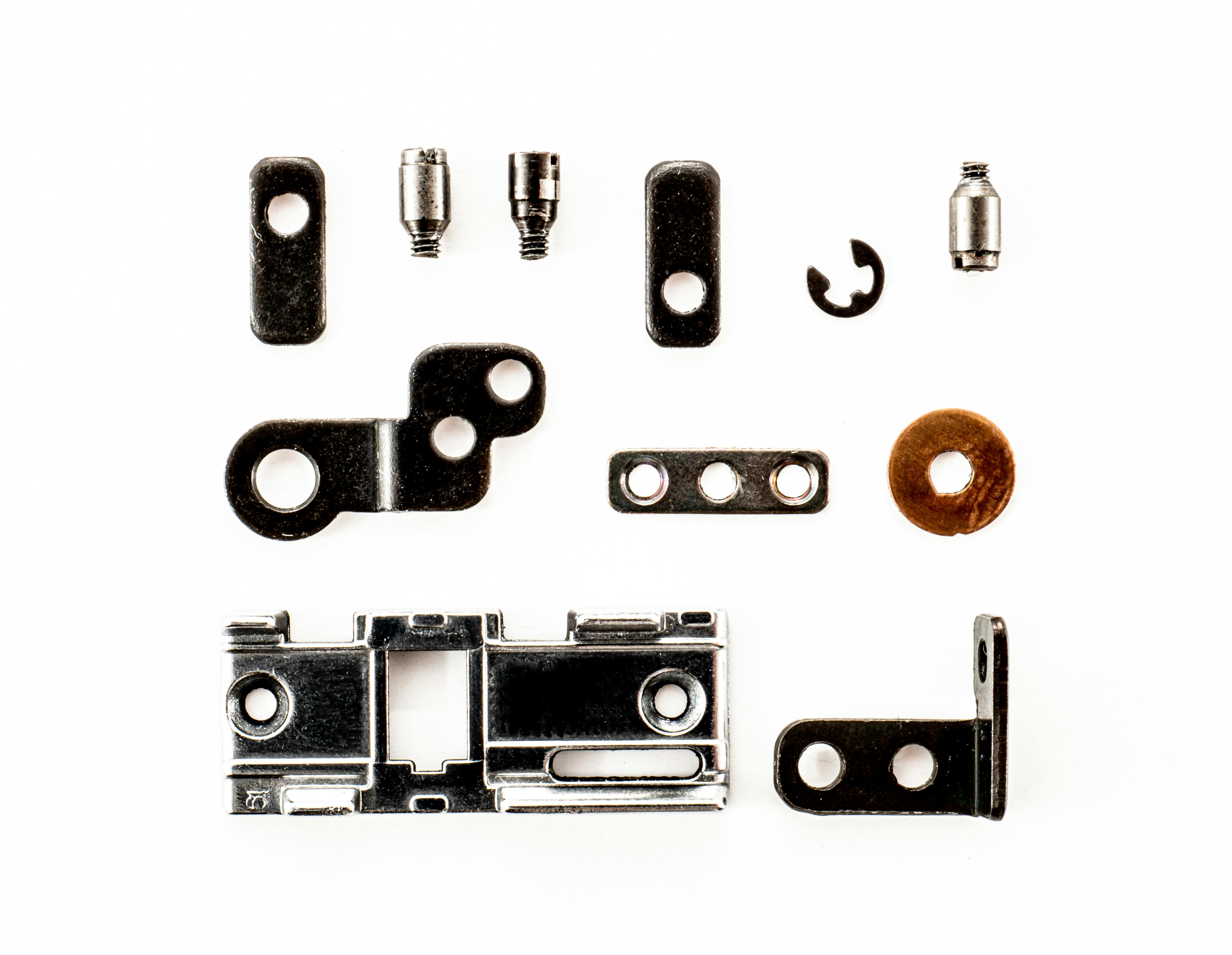 A top view of various metal fasteners arranged on a white background.