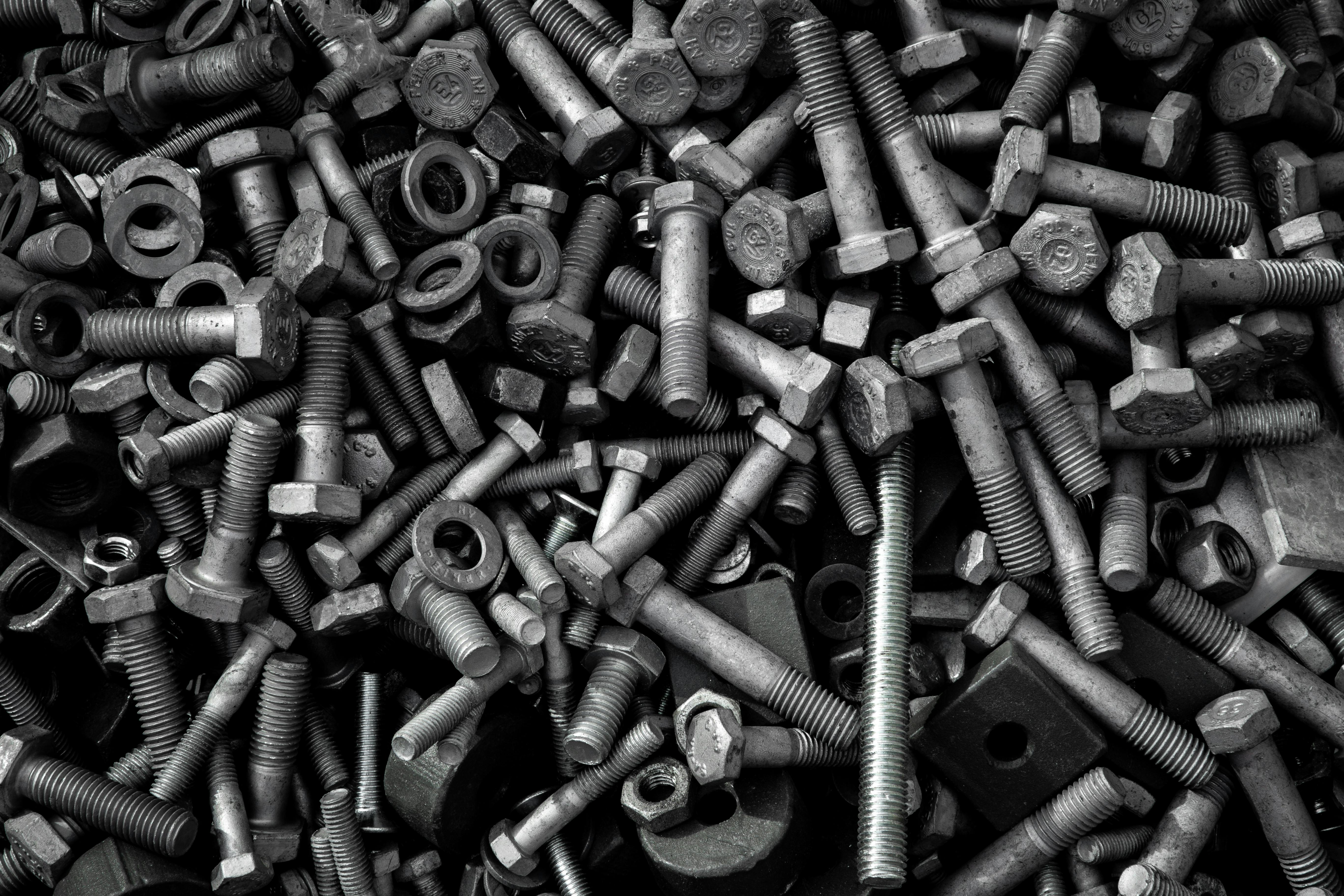 Detailed image of assorted industrial bolts and screws for recycling or mechanics.