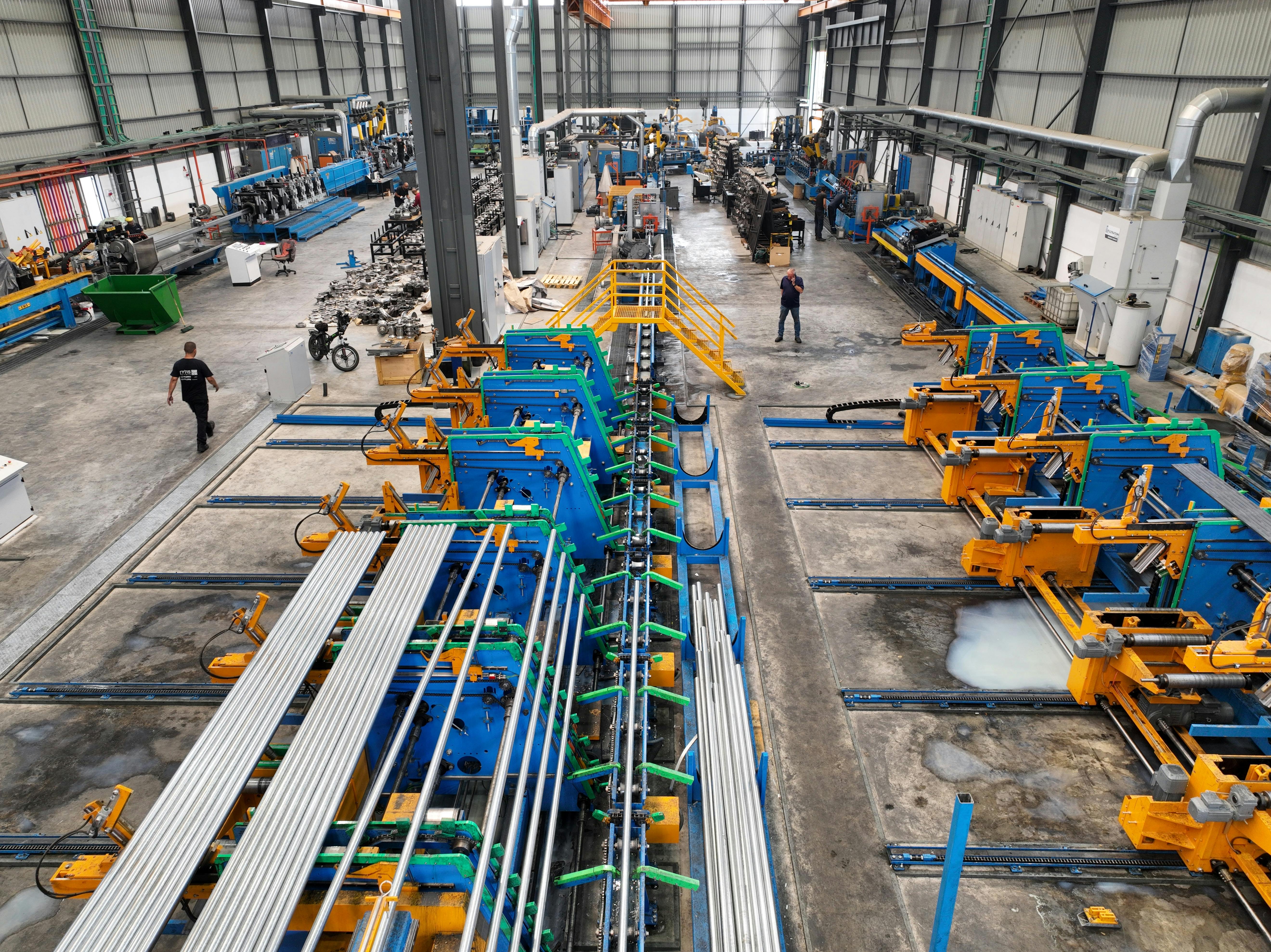 Aerial view of a large manufacturing plant interior with machinery and workers.
