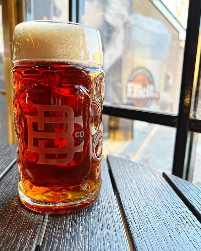 A glass of amber lager with hints of vanilla and allspice on a table at Elicit Brewing.