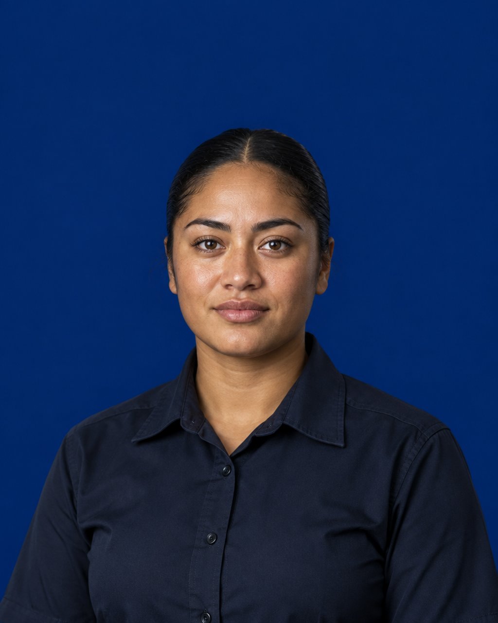 A calm young recruit in a plain dark shirt against a deep navy studio backdrop