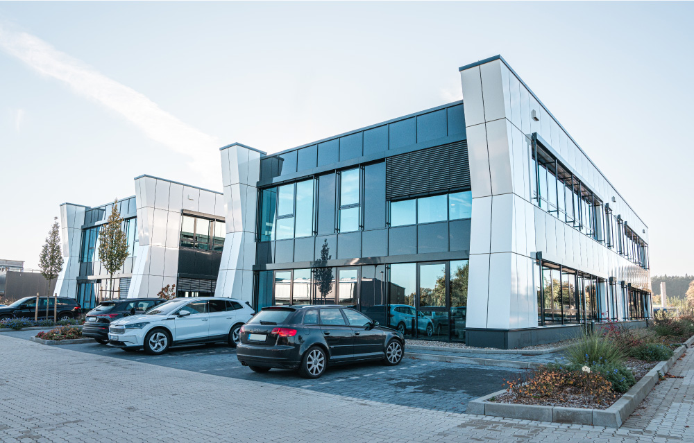 Ansicht eines Bürogebäudes mit parkenden Autos davor