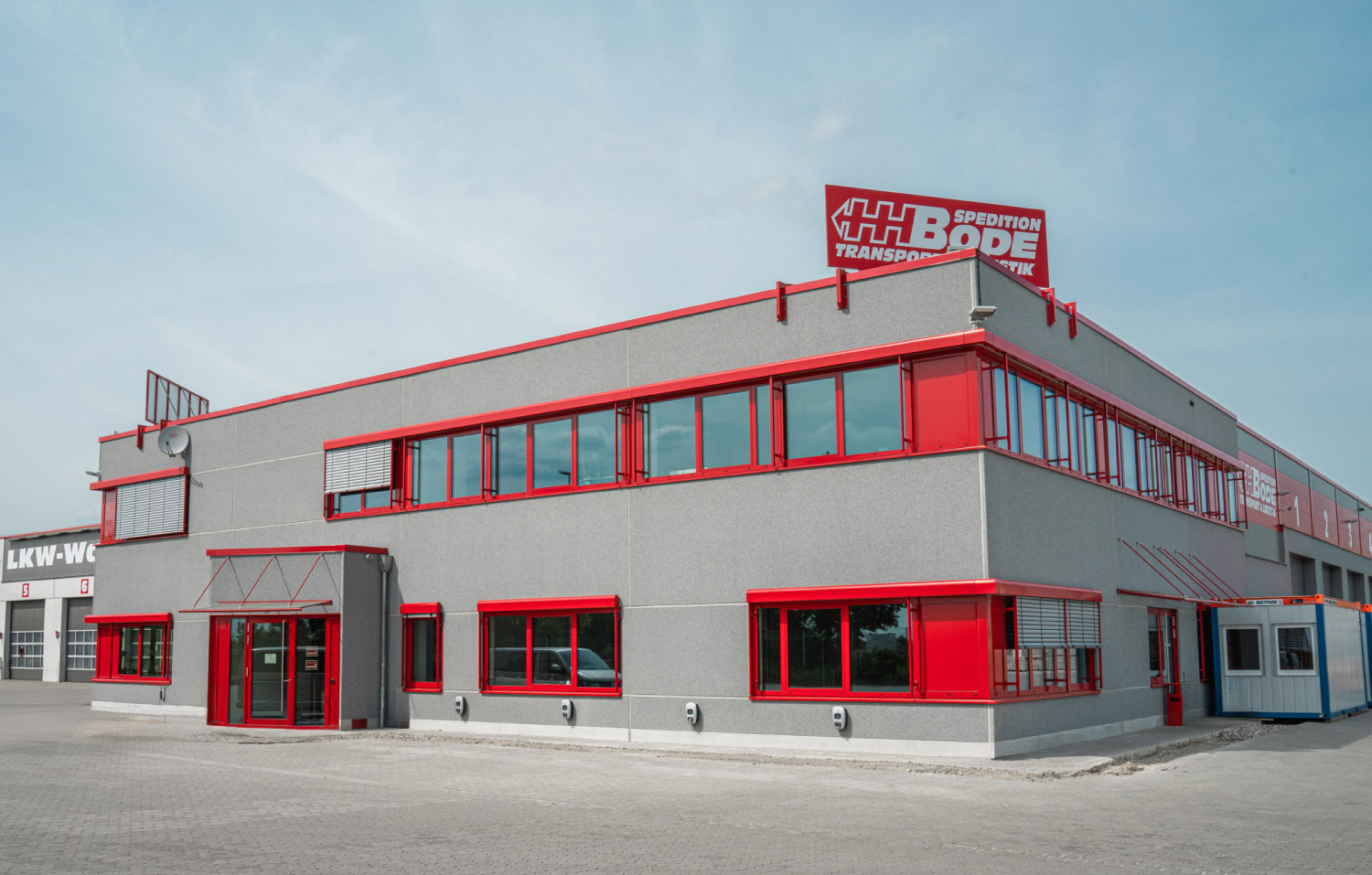 Ansicht eines Bürogebäudes mit parkenden Autos davor